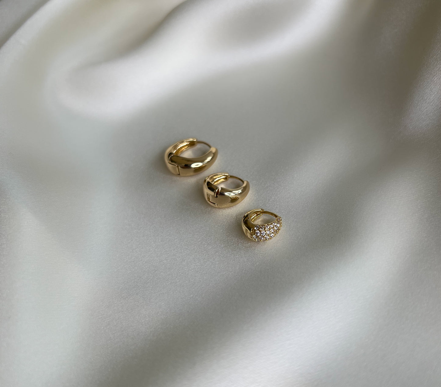 earring set. 3 pairs of teardrop shaped chunky gold hoops . Mix and match earrings. 16mm waterproof gold hoops. 13mm waterproof gold hoops. 10mm micro pave gold huggies.