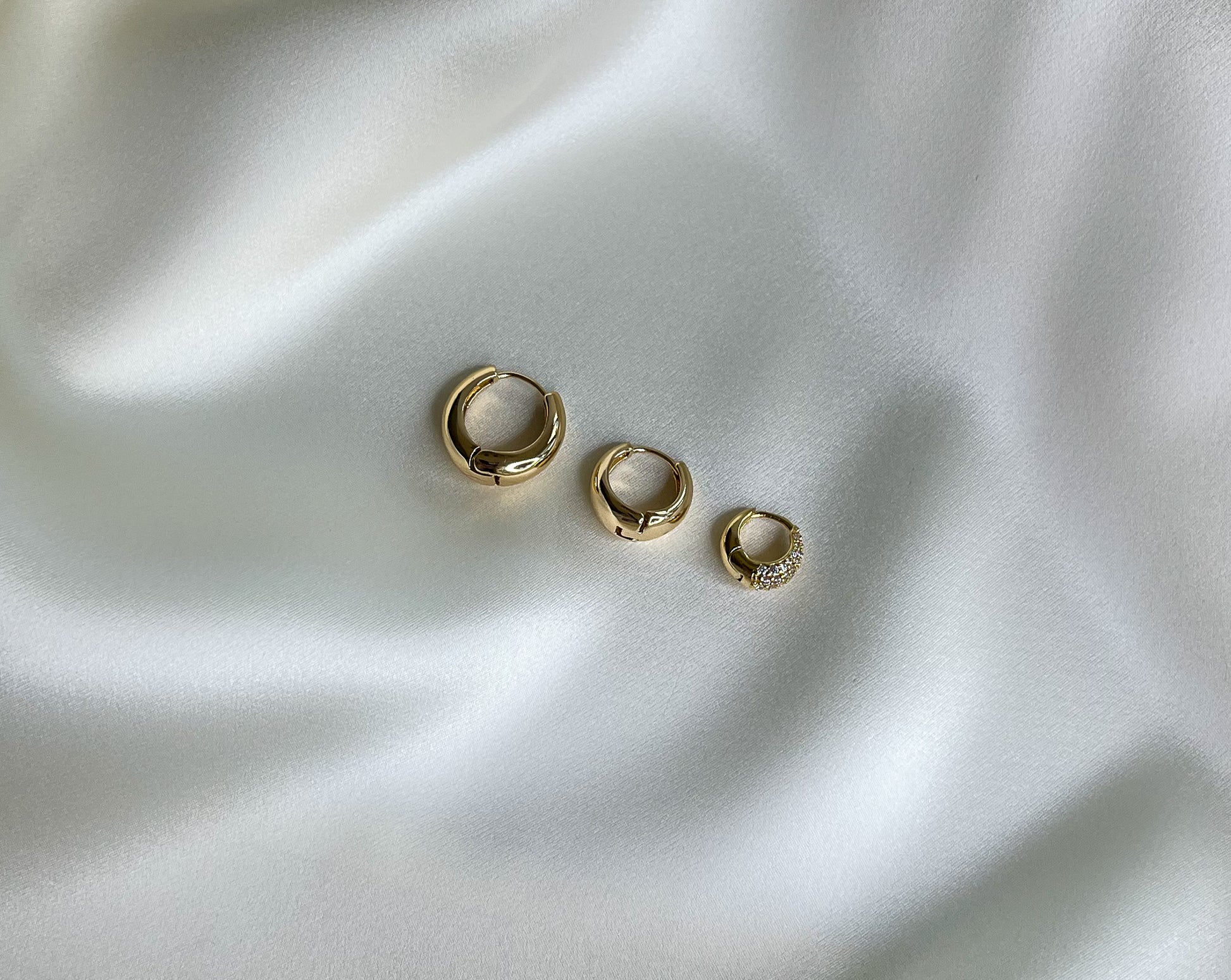 earring set. 3 pairs of teardrop shaped chunky gold hoops . Mix and match earrings. 16mm waterproof gold hoops. 13mm waterproof gold hoops. 10mm micro pave gold huggies.