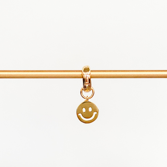 rose gold huggie with gold smily face charm