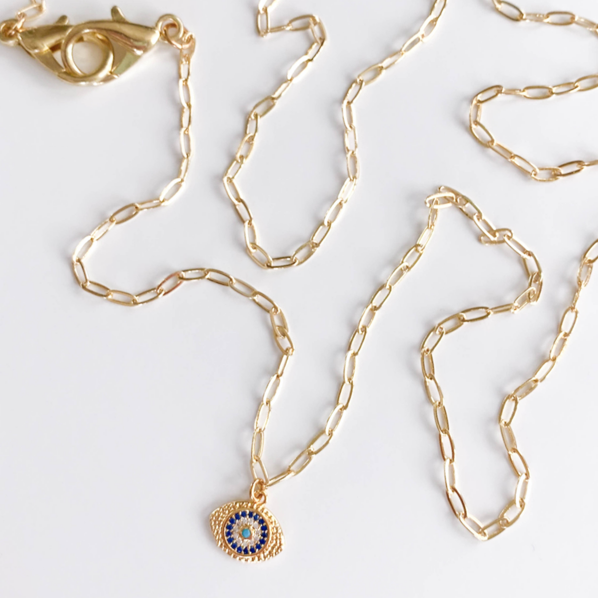 gold paperclip chain with blue and gold stone evil eye